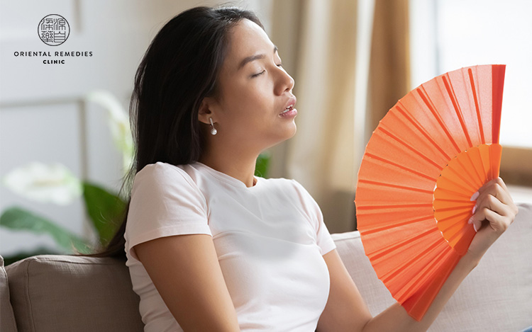 Middle aged woman experiencing hot flashes symptoms